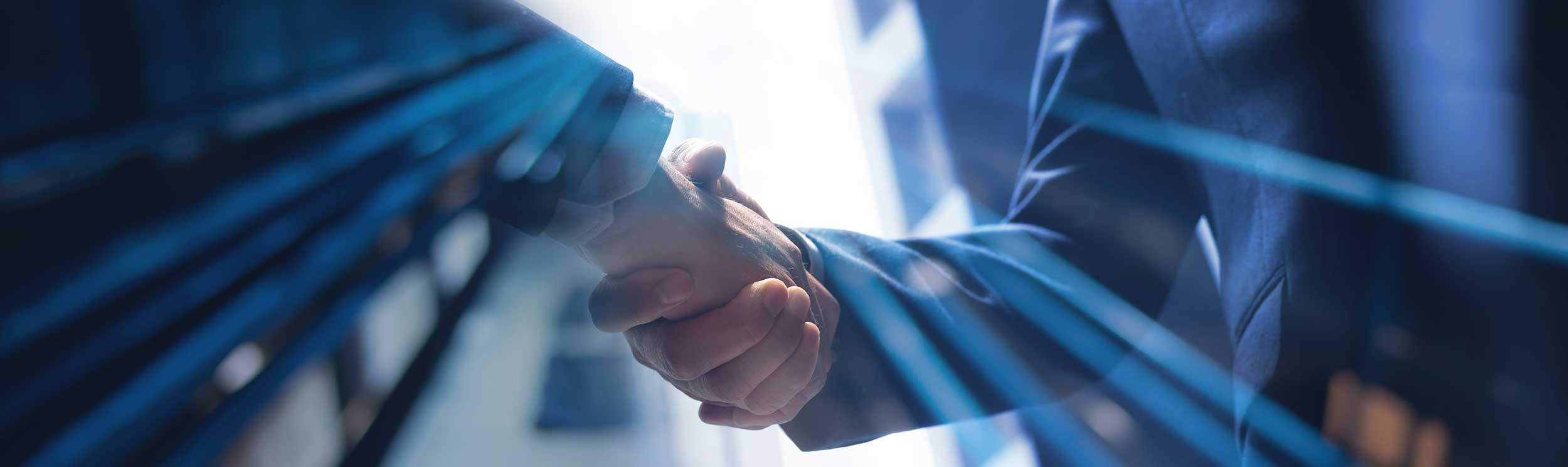 Händedruck zwischen zwei Geschäftspartnern als Symbol für Vertrauen, Zusammenarbeit und Partnerschaft auf Augenhöhe.