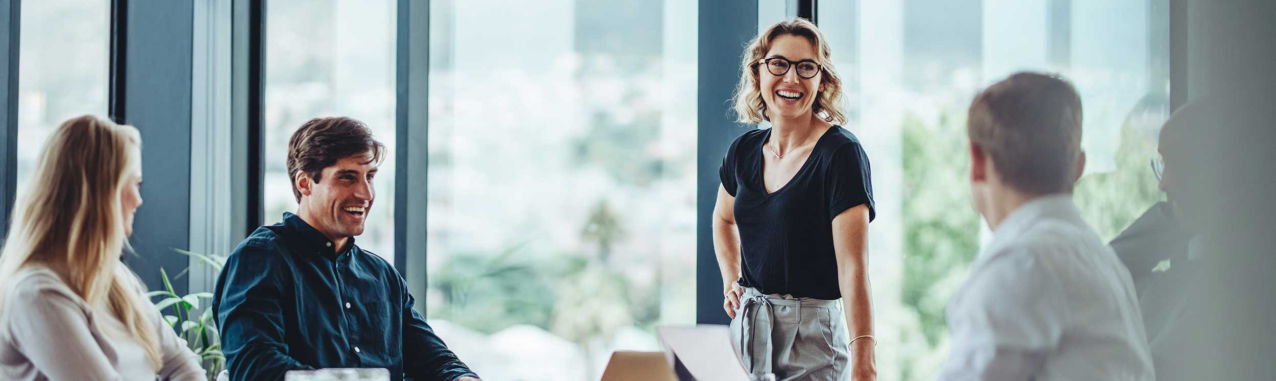 Team im Gespräch in einem modernen Büro als Symbol für Zusammenarbeit, Führung und Entwicklung im Rahmen des Win³ Programms.