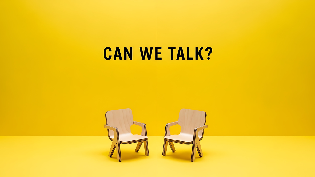 Zwei Stühle vor gelbem Hintergrund mit der Aufschrift „Can we talk?“ als Symbol für Harmonie im Unternehmen für Harmonie im Unternehmen und offene Gesprächskultur