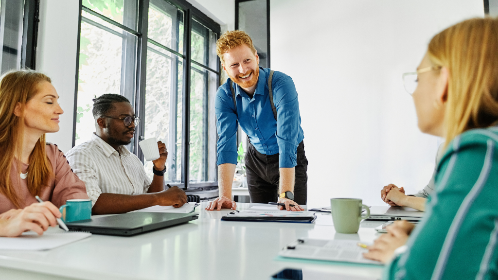 Führungskraft im Austausch mit ihrem Team als Beispiel für moderne Führung, die auf Zusammenarbeit, Vertrauen und gemeinsame Verantwortung setzt.